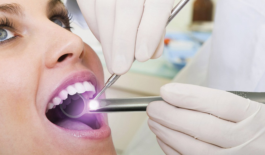 Closeup of a woman receiving an oral cancer screening at a dental office