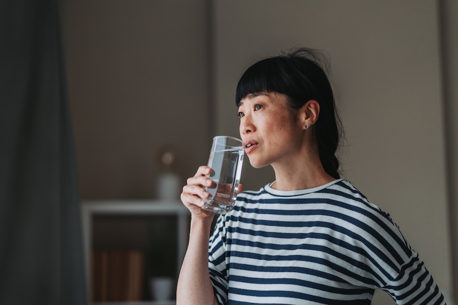 woman with dry mouth drinking water